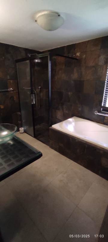 Bathroom with bathtub shower, modern sink and tiles in Clayton rental house Panama