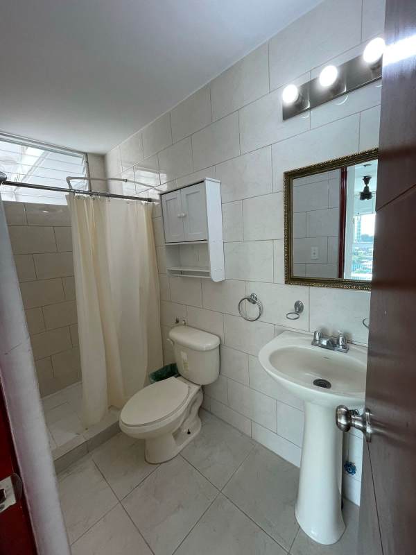 Modern tiled bathroom with pedestal sink, shower, wall mirror in PH Central Park Panama City