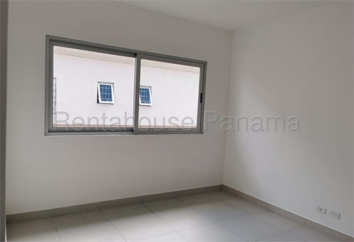 Bright bedroom with large sliding window in Altos del Parque Condado del Rey Panama City