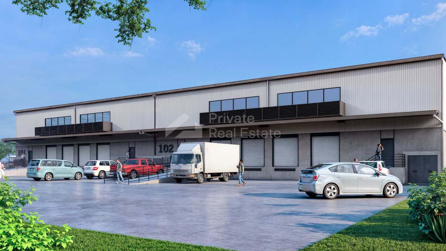 Front view modern industrial warehouse with multiple loading bays and delivery trucks Tocumen Commercial Park Panama