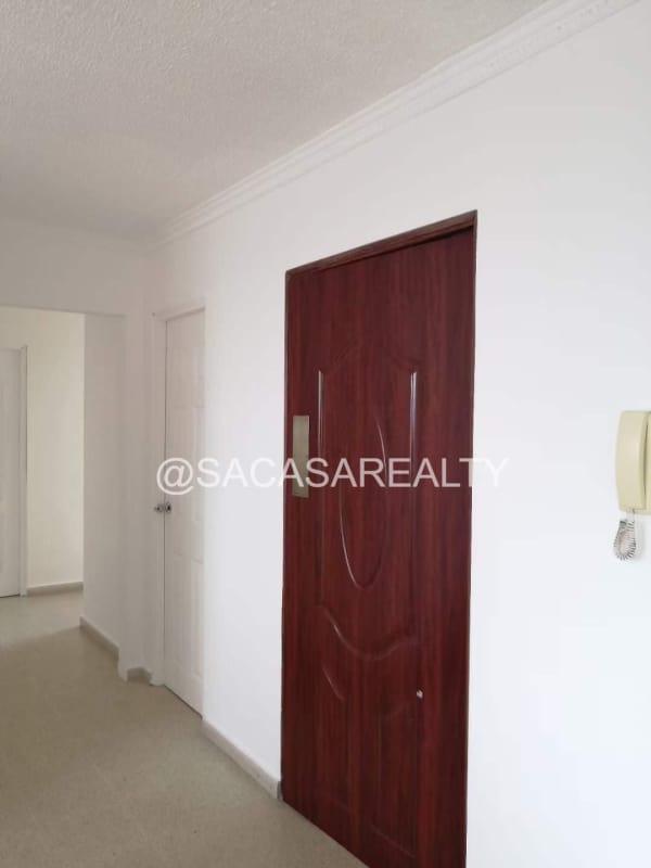 Apartment hallway with wooden entrance door and white walls PH Villa de las Fuentes El Dorado Panama City