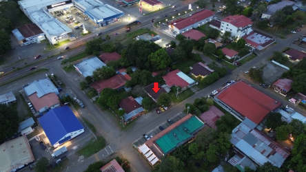 Aerial urban overview with commercial buildings, residences, and mountain backdrop in David near Volcán