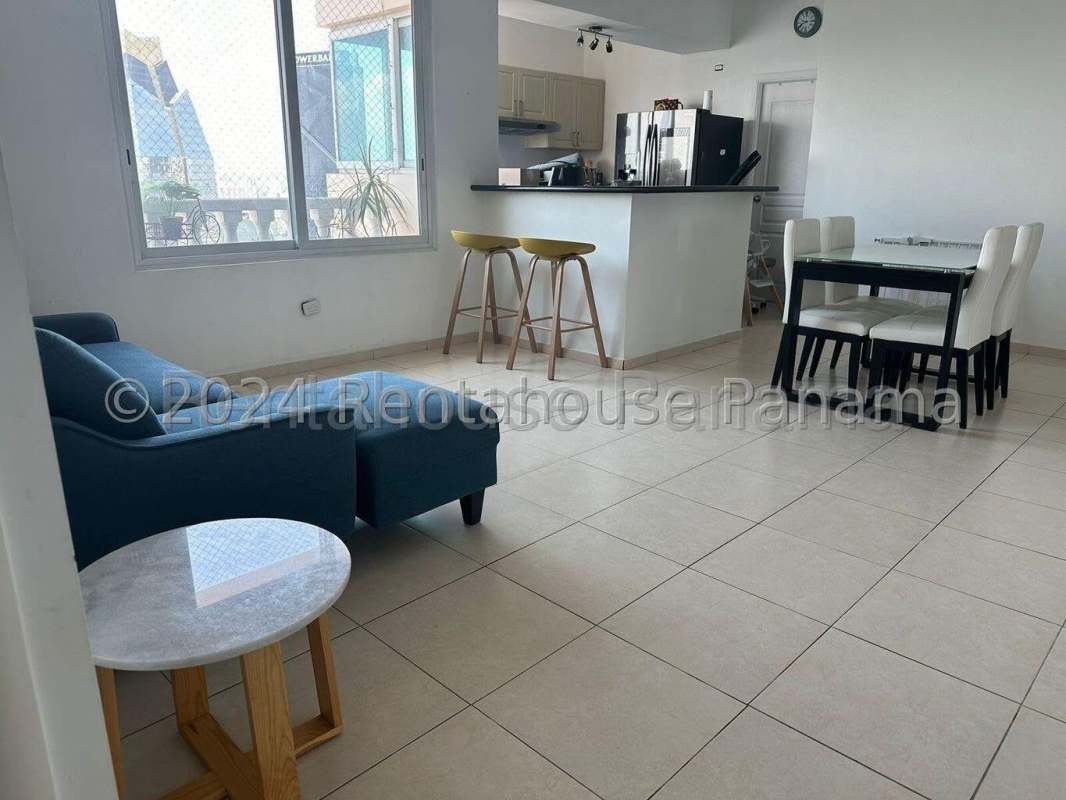 Open plan living area with blue sofa and kitchen at PH BICSA Financial Center