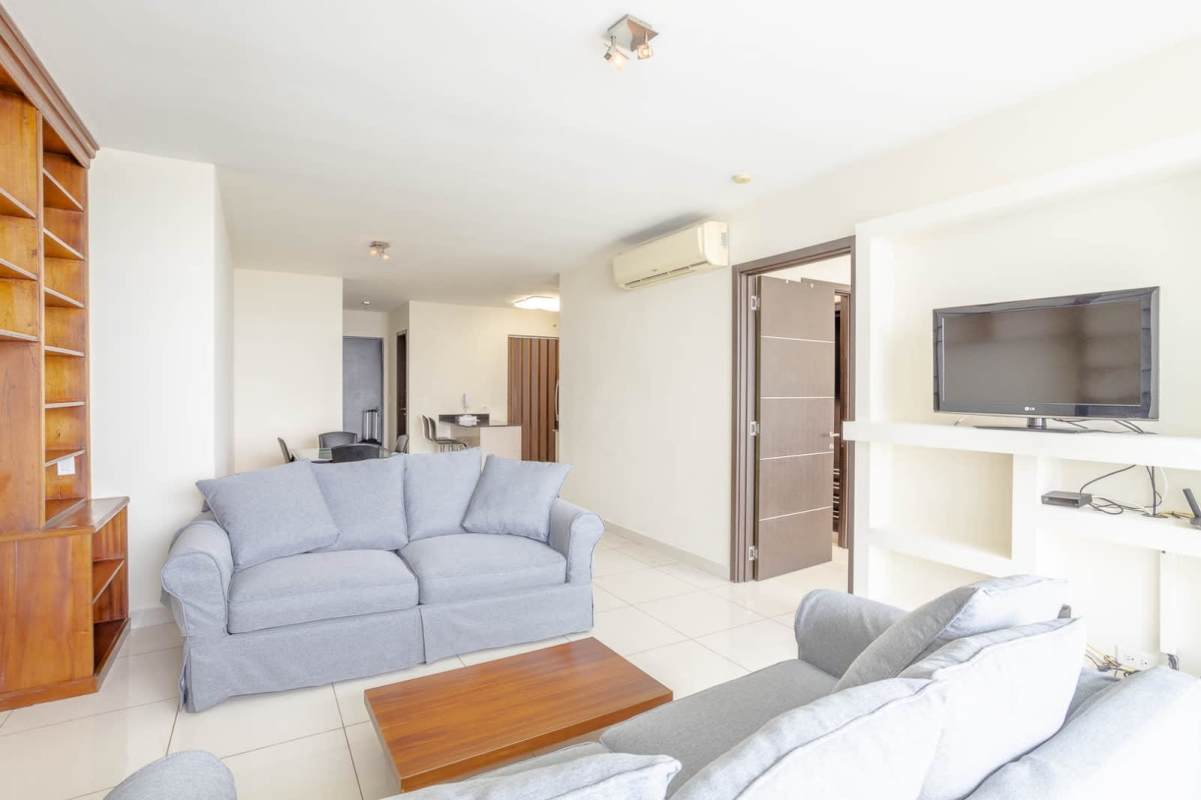 Modern living room with large windows overlooking the ocean and city in PH Allure at the Park Panama City