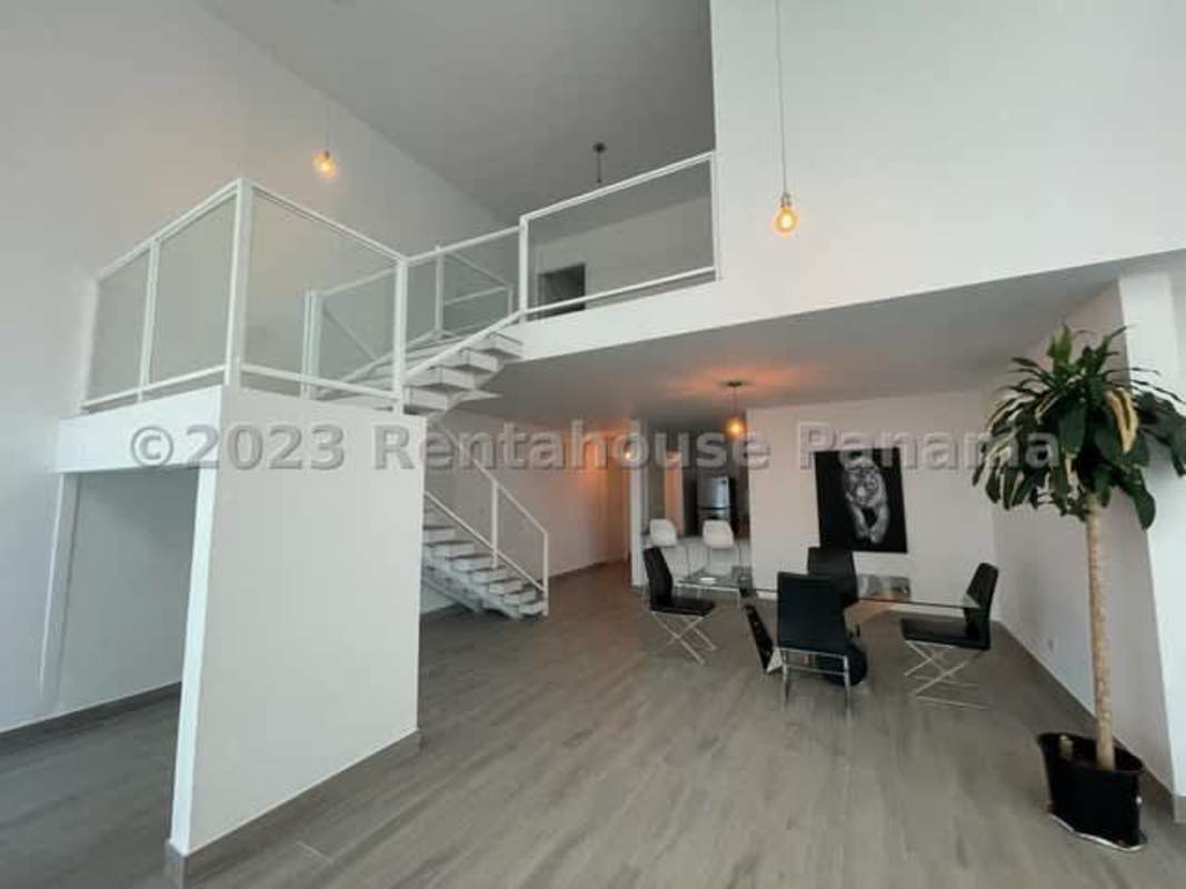 Bright living room space with city views, large windows and balcony access in Bella Vista Loft Tower apartment for rent by Hola Realty