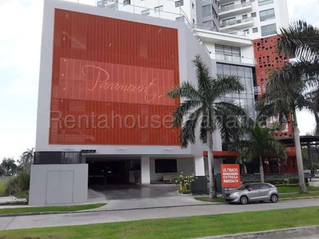 Luxury condominium tower with glass windows and palm trees entrance Costa del Este