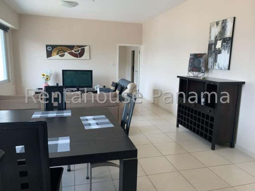 Open-plan living-dining area with large windows overlooking Panama City waterfront