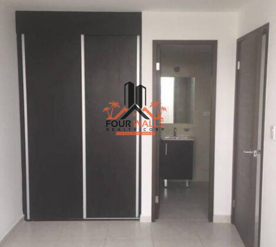 Bedroom with dark wood built-in closets, ensuite bathroom, and tile floor in PH Bay View Avenida Balboa Panama