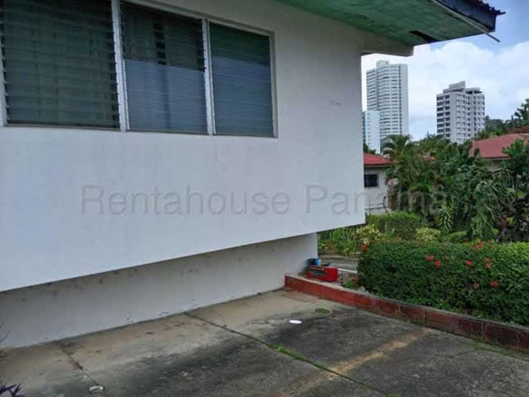 Bedroom featuring built-in wooden closet sliding doors and window garden view in San Francisco house Panama