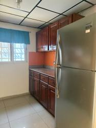 Kitchen with wood cabinets, refrigerator, stove orange backsplash Villa Mercedes David Panama
