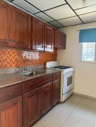 Kitchen interior wooden cabinets granite counter orange backsplash house David Panama