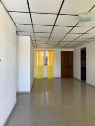 Empty living space with tiled floor window and yellow curtains David Panama