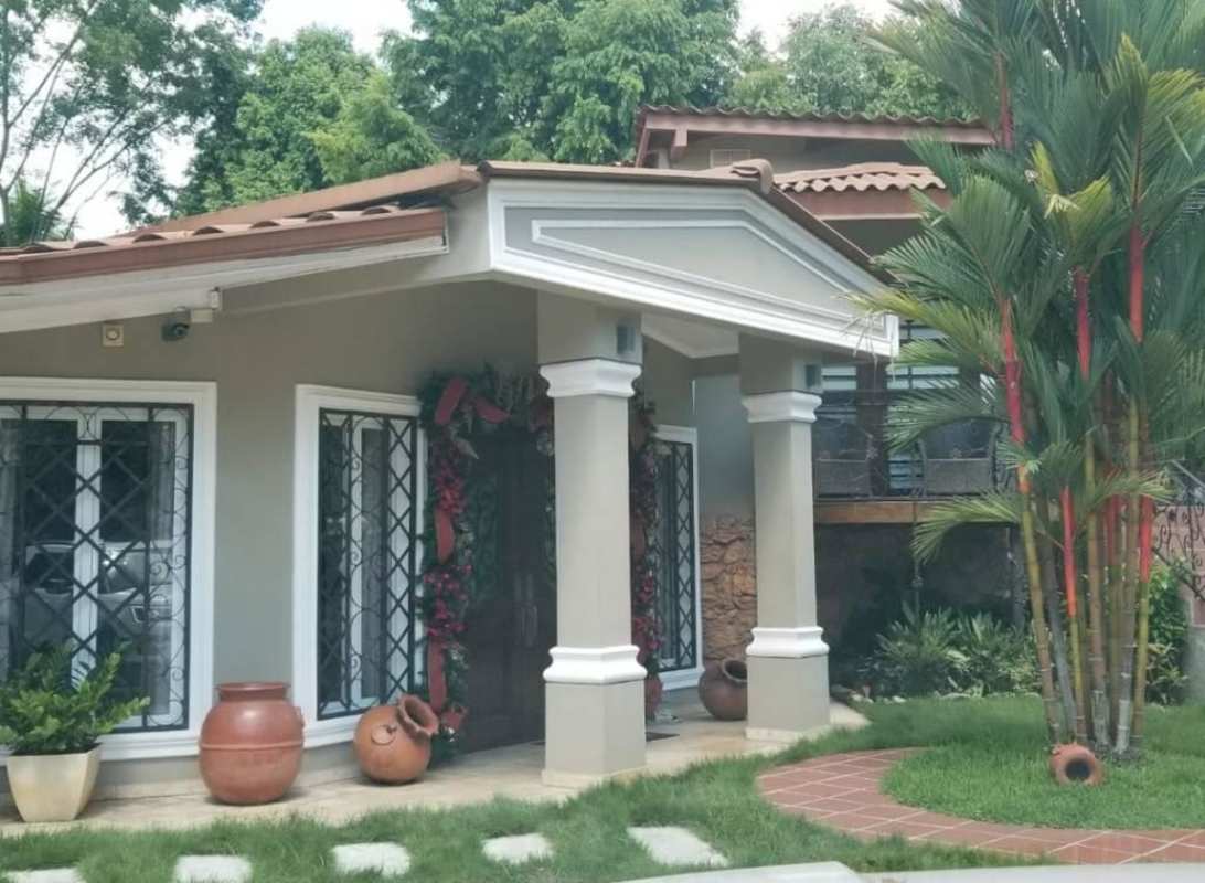 Bright large living room with white sofas, glass table and mirror in furnished rental house in Ancón Panama