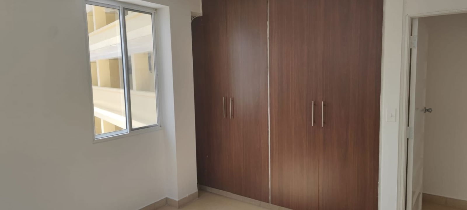 Bedroom interior with wardrobe, large window, tile floors PH Vía Argentina apartment El Cangrejo Panama rental