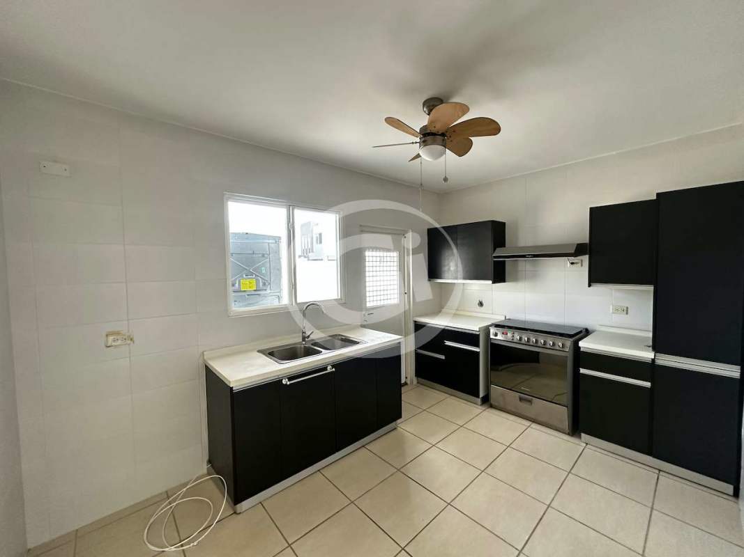 Kitchen with black cabinets, double sink, stove, oven in PH Augusta Brisas del Golf Panama