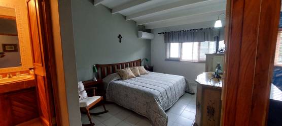 Open plan living dining blue accent wall wicker furniture at APRUCC beach duplex Nueva Gorgona Panama