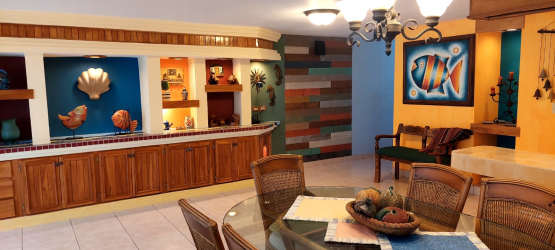 Coastal-style dining room glass table wicker chairs colorful wall APRUCC Nueva Gorgona Panama