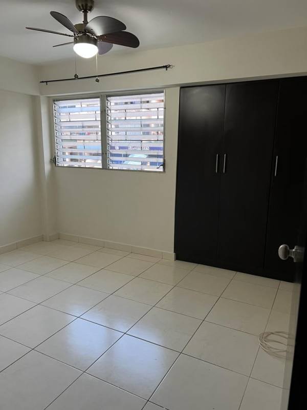 Compact bathroom with vessel sink, granite counter, walk-in shower, tile walls in apartment San Miguelito