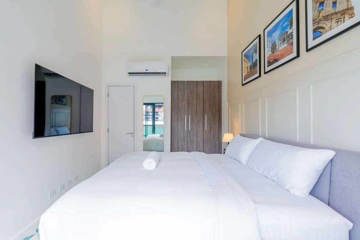 Spacious bedroom with king-size bed, wardrobe, air conditioning, minimalist decor in Casco Viejo Panama