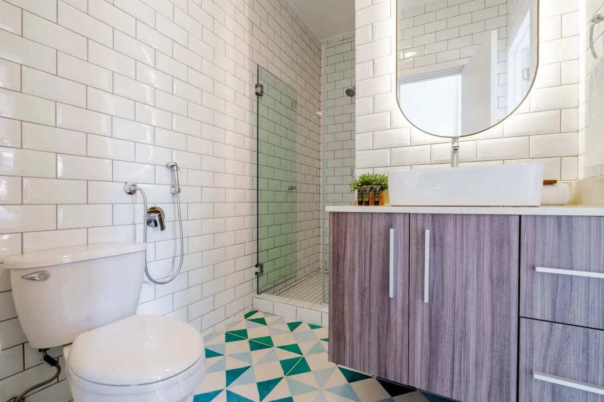 Modern bathroom with floating vanity, vessel sink, glass shower, white subway tiles in historic Casco Viejo apartment