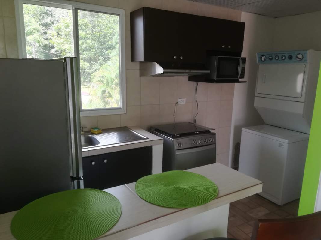 Studio kitchen with refrigerator, stove, microwave, washer/dryer stacked in Casa 725 Clayton Panama