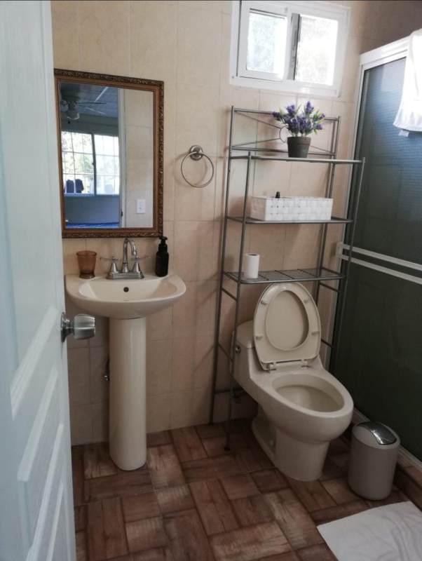 Minimalist bedroom with bed, desk, large window inside studio Casa 725 Clayton Panama