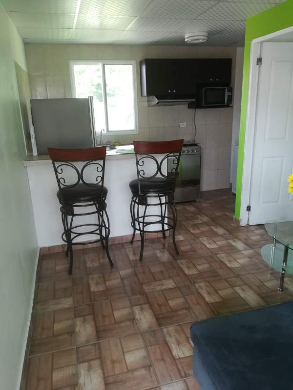 Kitchen with breakfast bar, stools, microwave, fridge inside studio in Casa 725 Clayton Panama