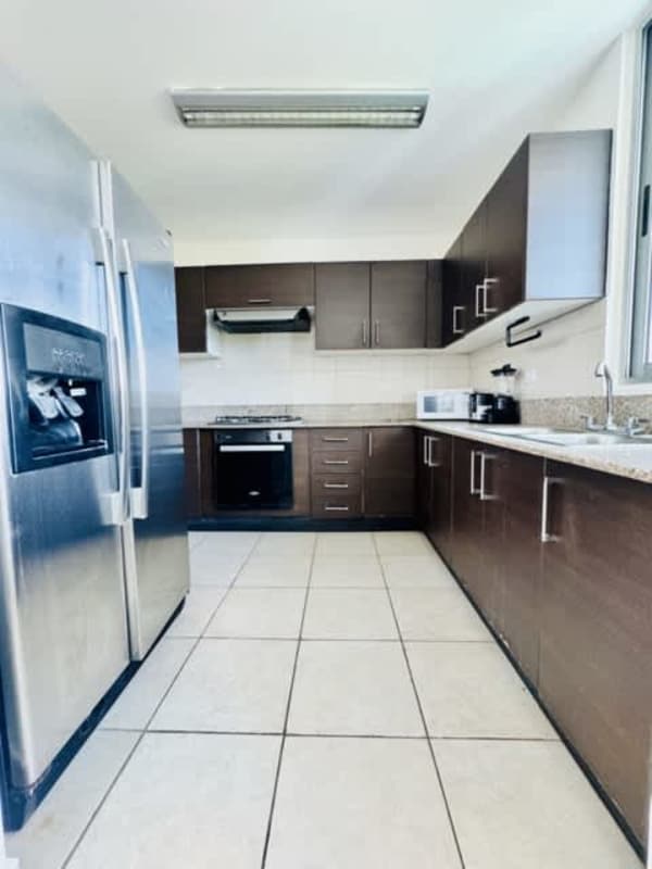 Kitchen with brown cabinetry, granite countertop and stainless appliances PH Clayton Park Clayton Panama