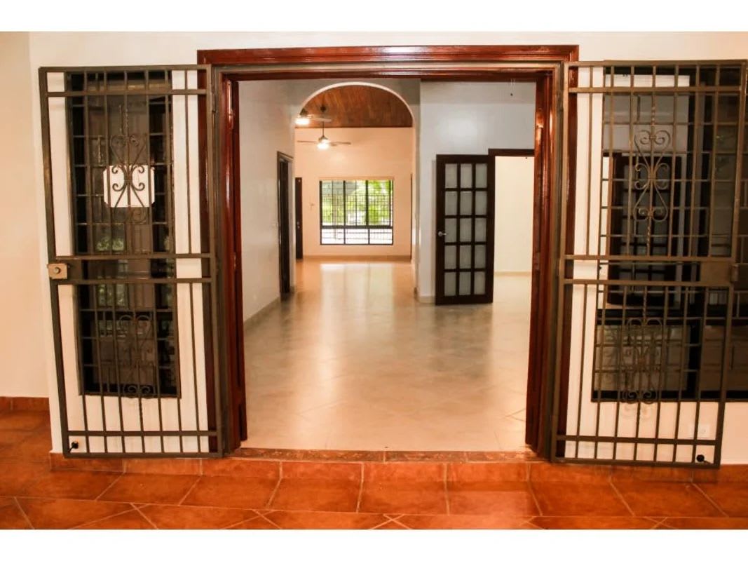 Front view of house with lawn, electric garage doors, in exclusive Cardenas Panama neighborhood