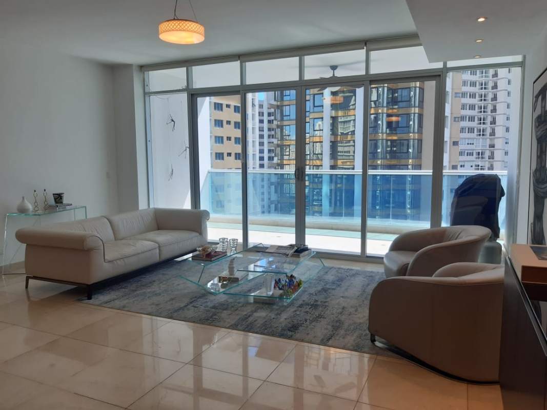 Modern living room with floor-to-ceiling windows, balcony ocean view at PH Aventura Punta Paitilla Panama rental