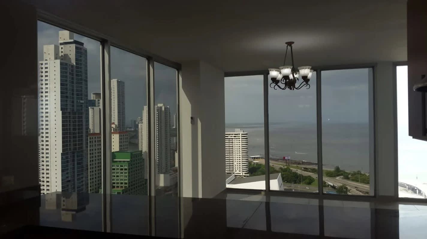 Living room with large panoramic windows ocean and skyline views in PH Privé Panama City