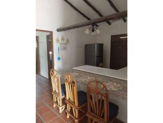 Rustic kitchen with exposed wood beams, terracotta tiles, breakfast bar with stools in Nueva Gorgona house
