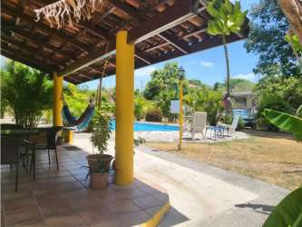 Large living area with exposed wooden beams and tile flooring in Coronado house Panama
