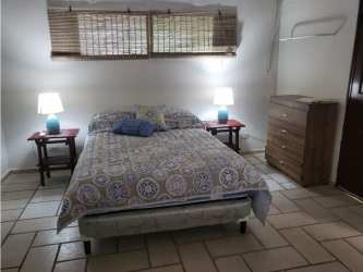 Cozy bedroom with wooden beams ceiling, tiled floor, furnished rental in Coronado Panama