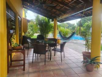 Covered terrace with hammock, dining table overlooking swimming pool in Coronado rental Panama