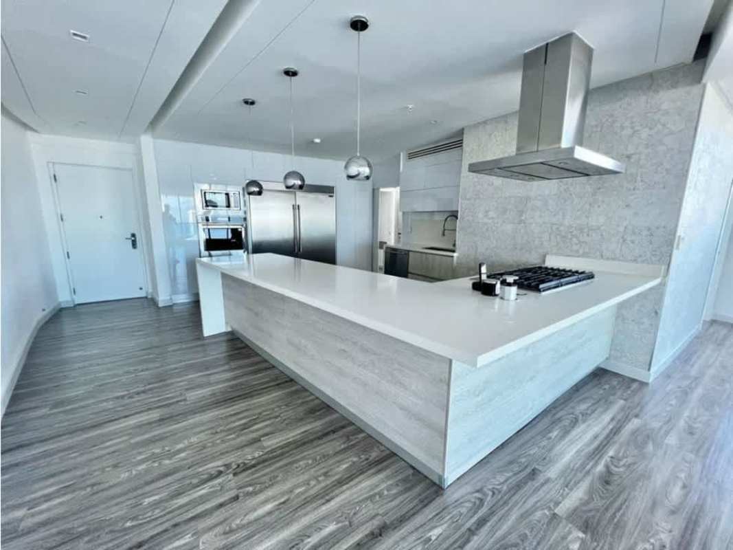 Luxury apartment kitchen with island, stainless appliances, pendant lights, hardwood flooring in PH Joy Tower Panama City