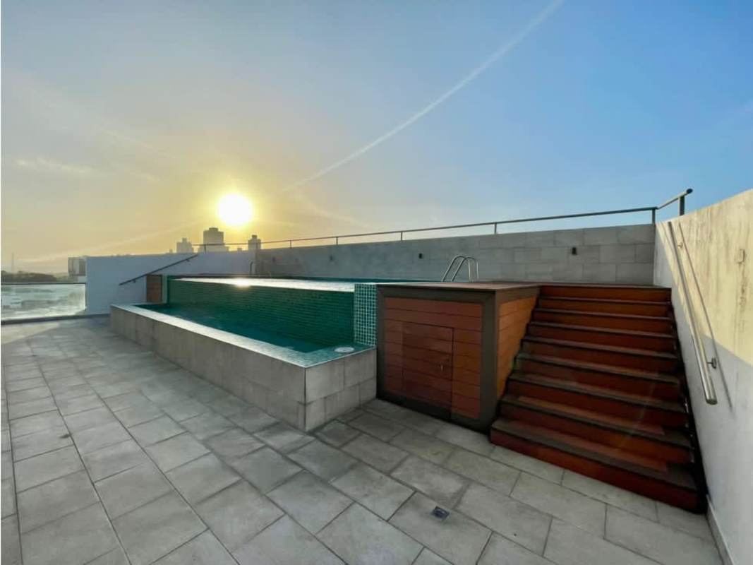 Rooftop swimming pool with wooden deck and city skyline sunset view at PH Scala Panama City