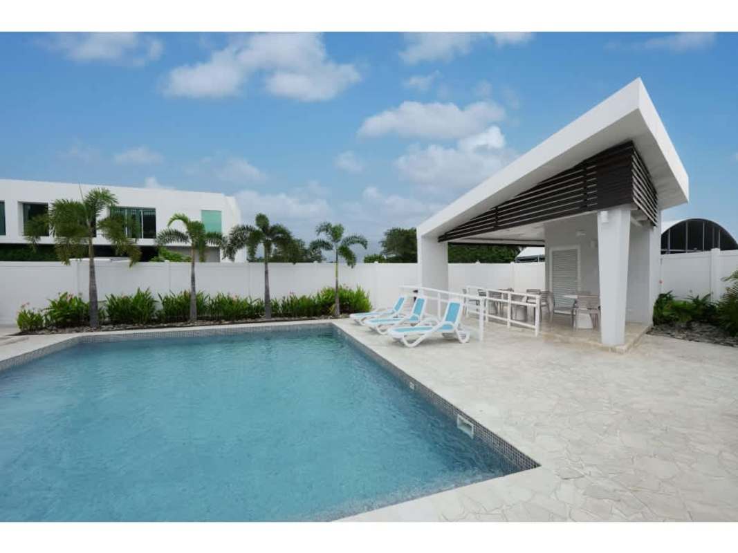 Large outdoor swimming pool with lounge chairs at Panama Viejo Residences in Chanis Panama City