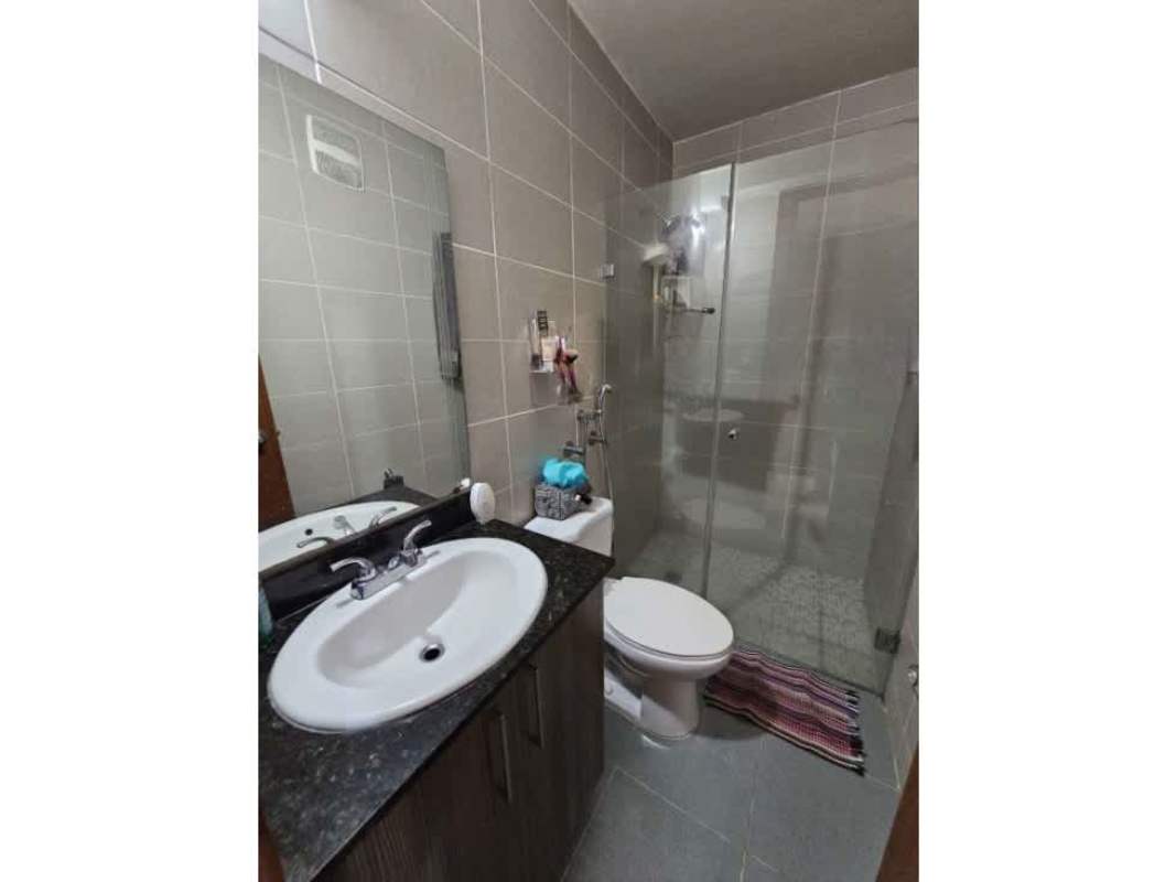 Bathroom with glass enclosed shower, vanity and grey tiles at Residencias del Sol Carrasquilla Panama