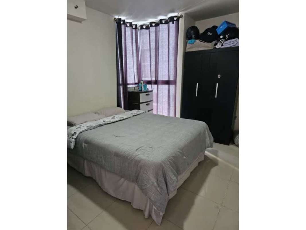 Modern bedroom with large window, navy bedding, and wardrobe in PH Residencias del Sol Panama City