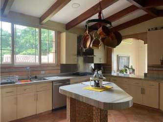 Rustic contemporary kitchen featuring beams, large island, natural light in San Carlos estate property