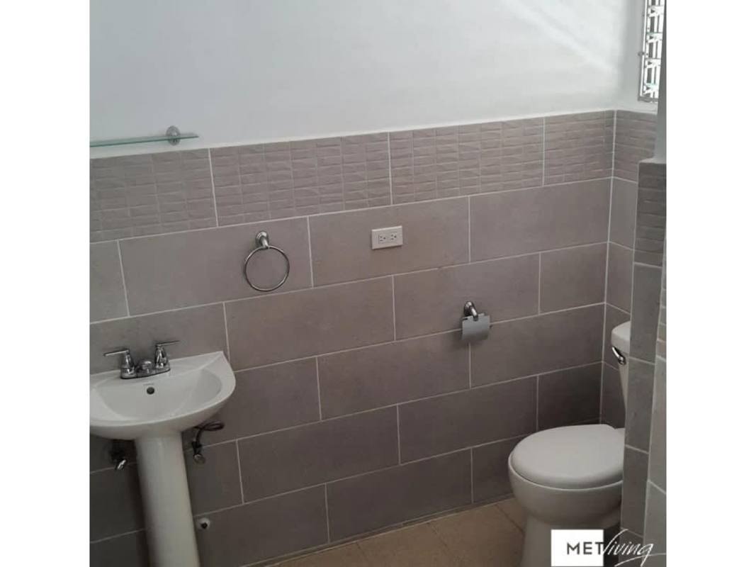 Bright empty living area with large window and wood tile floors in San Francisco Panama