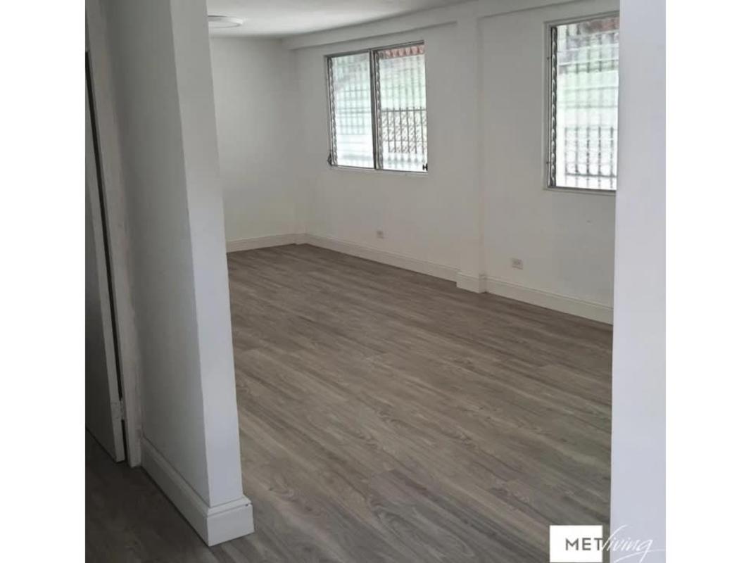 Minimalist empty office room with large window and wood flooring in San Francisco Panama