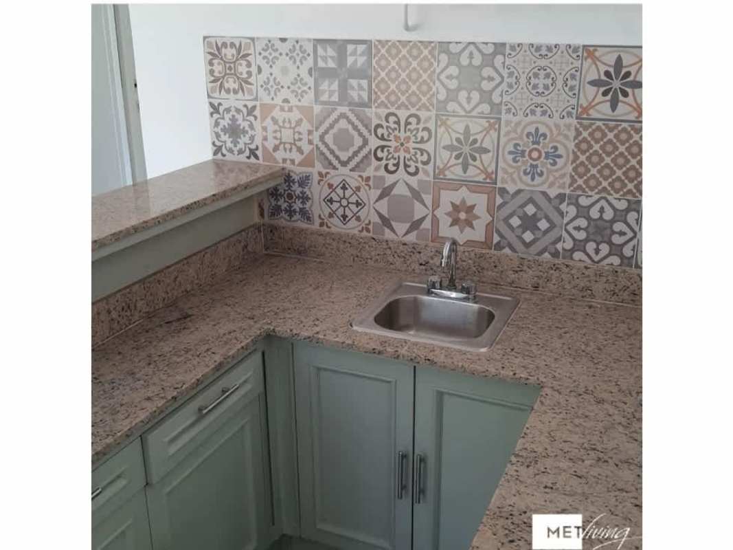 Minimalist bathroom with tiled walls, pedestal sink and toilet commercial house Panama