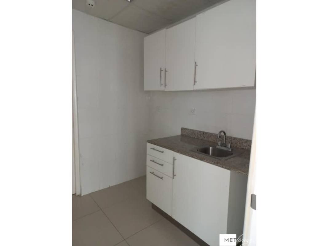 Compact office kitchenette with granite countertop, white cabinetry, single sink in commercial office El Cangrejo Panama
