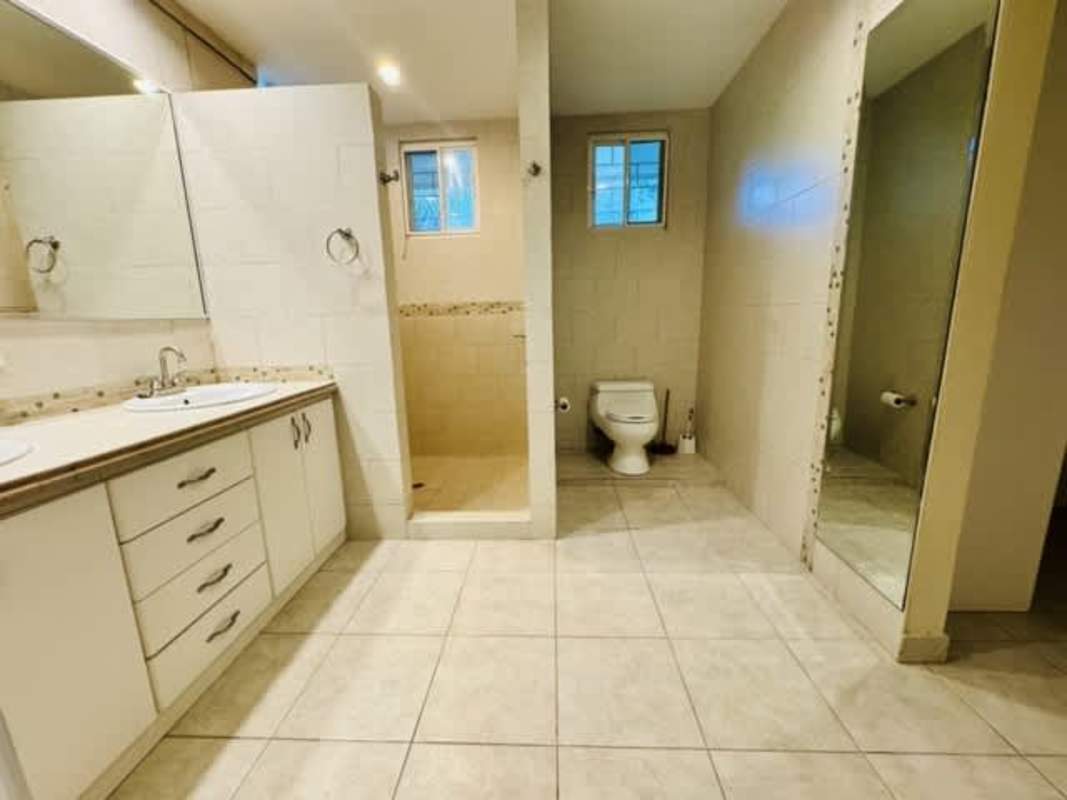 Modern spacious bathroom with double sink vanity and walk-in shower in Cardenas rental house.