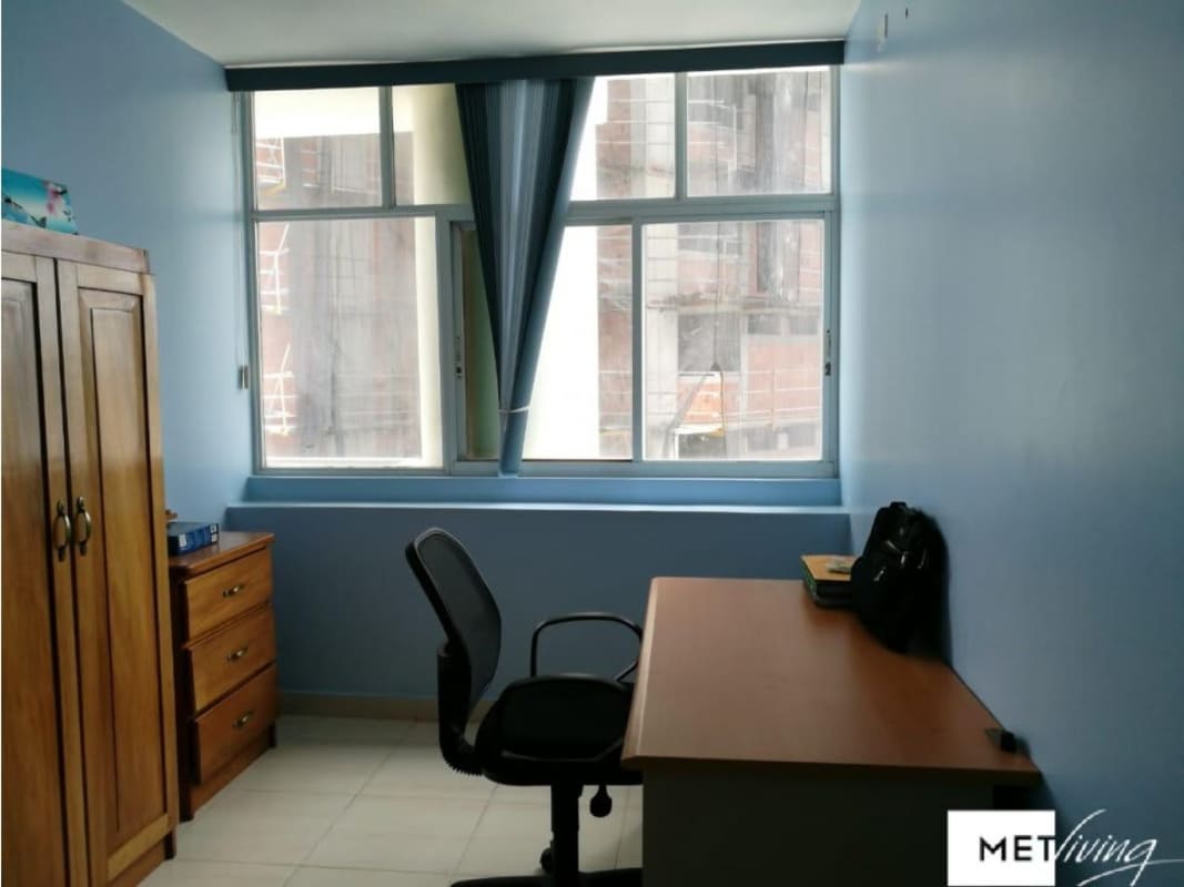 Home office with desk, wardrobe, light blue wall Edison Park Panama apartment