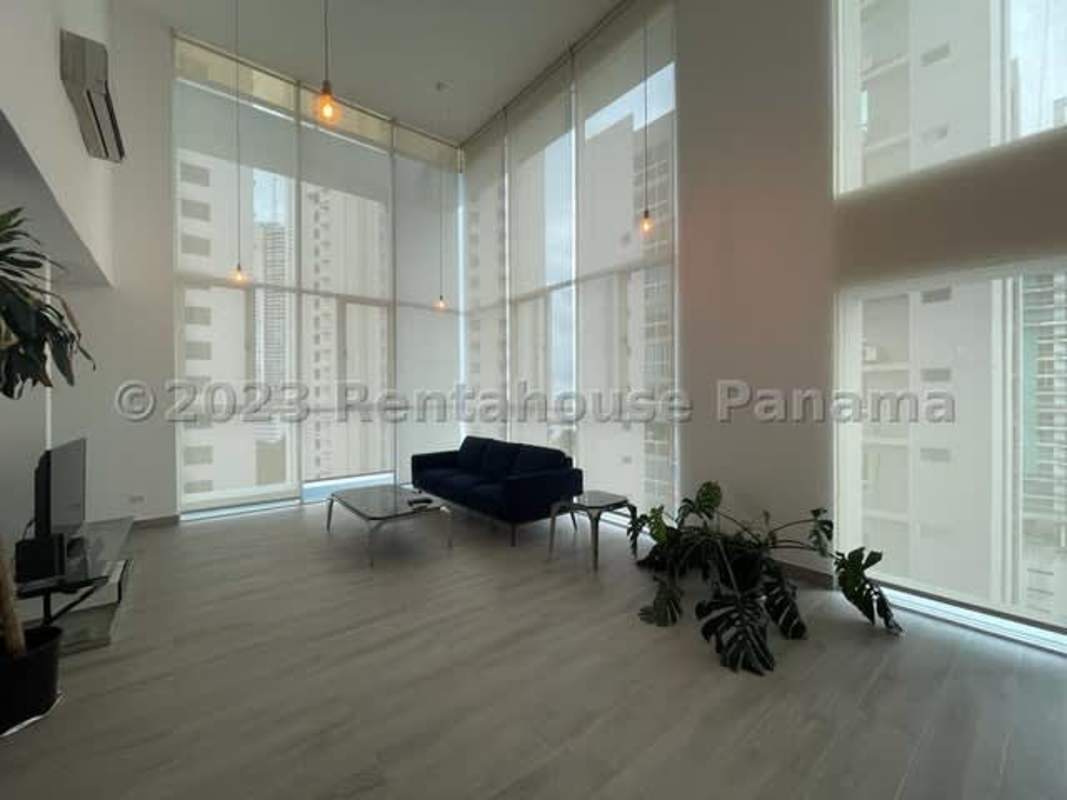 Top mezzanine area overlooking living room with glass railing in PH Blue Park Panama City