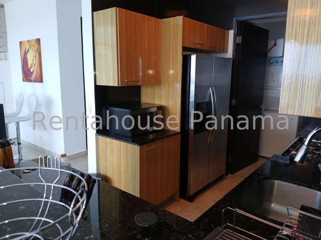 Modern kitchen with granite countertops, wood cabinets, stainless steel appliances at PH Sky Avenida Balboa
