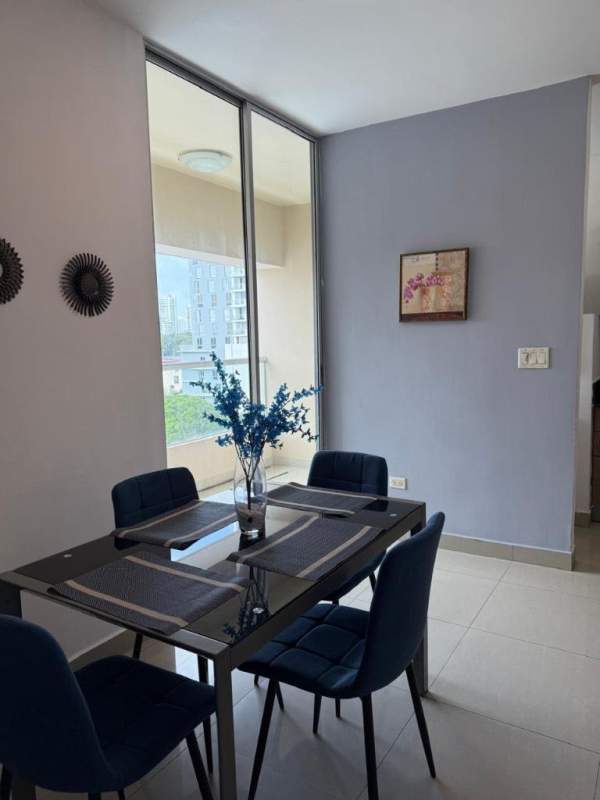 Dining area with blue chairs near large window and city views in PH San Francisco Bay Panama